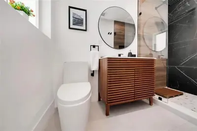 a bathroom with a toilet and a sink and a mirror at 4BR Lakefront Heated Pool -Jacuzzi -Basket -Sauna in Fort Lauderdale