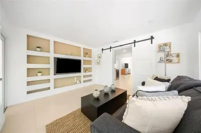 a living room with a couch and a tv at 4BR Lakefront Heated Pool -Jacuzzi -Basket -Sauna in Fort Lauderdale