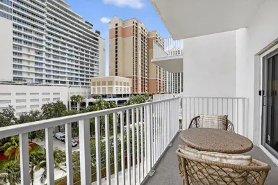 a balcony with a table and chairs and buildings at Beach Haven Condo for 2 in Fort Lauderdale