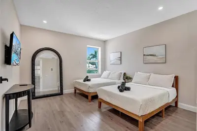 a bedroom with two beds and a mirror at 6BR Elegant Hollywood Lakes Mansion with Pool & Spa home in Hollywood