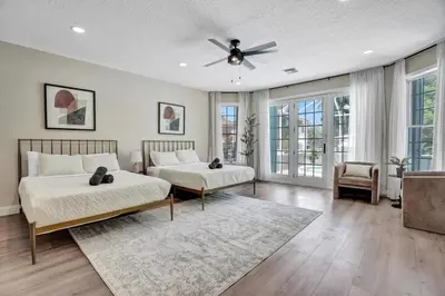 a bedroom with two beds and a ceiling fan at 6BR Elegant Hollywood Lakes Mansion with Pool & Spa home in Hollywood