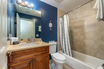 a bathroom with a sink and a toilet and a tub at Salty Fox 5BD Oasis w Spa, Beach & Downtown in Fort Lauderdale