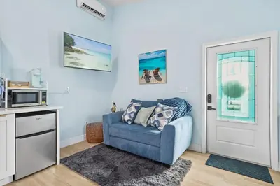 a living room with a blue couch and a microwave at Private Retreat with Yard Near Hard Rock Stadium in Miramar