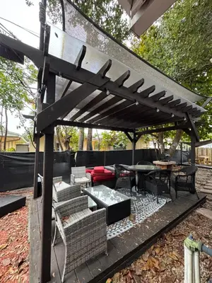 a wooden pergola with a table and chairs under it at Modern 2 BR near shops, WD fast WiFI 2000mbps 10 min to beach Bliss 7 in Hollywood