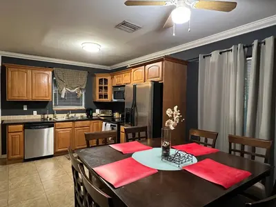 a kitchen with a dining room table with red napkins at Modern 2 BR near shops, WD fast WiFI 2000mbps 10 min to beach Bliss 7 in Hollywood