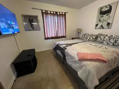 a bedroom with a bed and a flat screen tv at Modern 2 BR near shops, WD fast WiFI 2000mbps 10 min to beach Bliss 7 in Hollywood