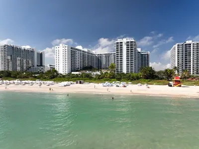 a beach with buildings and people in the water at South Beach Luxury 2 Bedroom Condo on the Ocean in Miami Beach