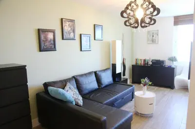 a living room with a black leather couch and a chandelier at South Beach Amazing Ocean View in Miami Beach