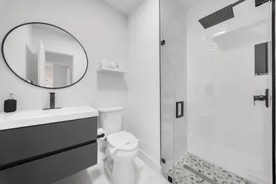 a bathroom with a toilet and a sink and a mirror at Azure Coastal Breeze in North Miami Beach
