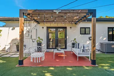 a pergola with a table and chairs on a patio at Azure Coastal Breeze in North Miami Beach