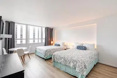 a hotel room with two beds and a table at A dreamed bay view studio at Castle Beach Club in Miami Beach