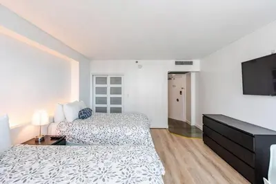 a hotel room with two beds and a flat screen tv at A dreamed bay view studio at Castle Beach Club in Miami Beach
