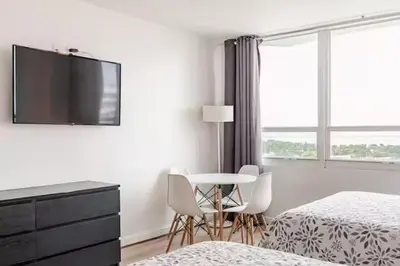 a white room with a table and chairs and a tv at A dreamed bay view studio at Castle Beach Club in Miami Beach