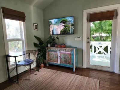 a living room with a flat screen tv on the wall at LUSH TROPICAL STUDIO in FT LAUDEDALE'S HISTORICAL SAILBOAT BEND NEIGHBORHOOD in Fort Lauderdale