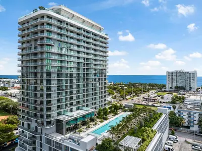 an aerial view of a tall building with a pool at 72 Park- Luxury Condo With Private Beach Access in Miami Beach