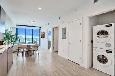 a kitchen and dining room with a washer and dryer at 72 Park- Luxury Condo With Private Beach Access in Miami Beach