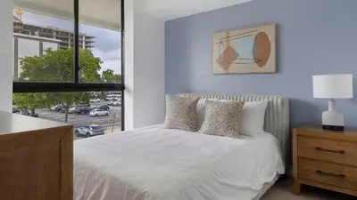 a bedroom with a white bed and a large window at Landing Chic 2BD Clubhouse Yoga Studio in North Miami