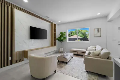 a living room with a couch and a tv on a wall at Villa Gabriel Modern, Family Home Just 15 minutes downtown Miami in Miami