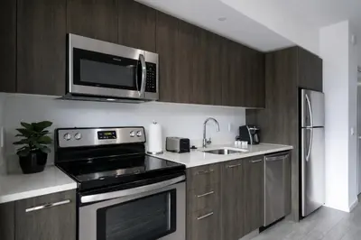 a kitchen with a microwave above a stove and a sink at Downtown Skyline Heights with Stunning Ocean View in Miami