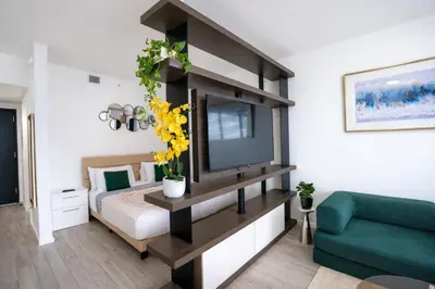 a bedroom with a bed with a tv and a couch at Downtown Skyline Heights with Stunning Ocean View in Miami