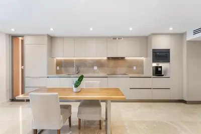 a kitchen with a wooden table and chairs at Amazing Ocean and 1 Hotel pool Views 2BR 3BA w Balcony in Miami Beach