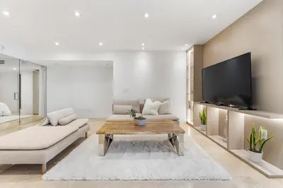 a living room with a couch and a tv at Amazing Ocean and 1 Hotel pool Views 2BR 3BA w Balcony in Miami Beach