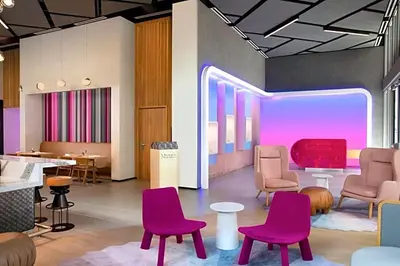a waiting room with purple chairs and tables at Stylish Studio in Brickell Core in Miami