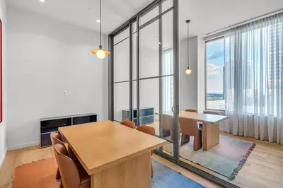 a dining room with a table and chairs and windows at Luxury 2 Bedroom Corner Unit Crosby Rooftop Pool in Miami