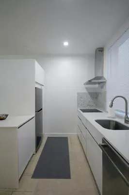 a kitchen with white counters and a sink and a window at Historical Little Havana 2 Bed with Parking in Miami