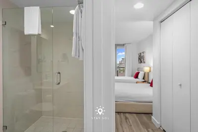 a bathroom with a shower and a bedroom with a bed at Amazing Apartment with Bay View Balcony Near Beach in Hallandale Beach