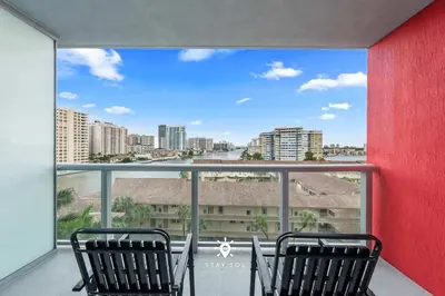 two chairs on a balcony with a view of the city at Amazing Apartment with Bay View Balcony Near Beach in Hallandale Beach