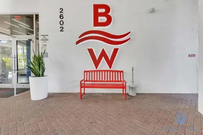 a red bench sitting in front of a w sign at Peaceful Bay View Apartment Near Beach in Hallandale Beach