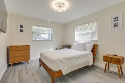 a bedroom with a bed and a dresser and two windows at Walk to Shops and Eats, 3 Mi to Beach! Hollywood Gem in Hollywood