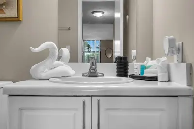 a bathroom counter with a sink and a mirror at Stylish 2BR in North Miami with Free Parking in North Miami
