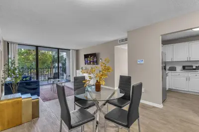 a kitchen and dining room with a glass table and chairs at Stylish 2BR in North Miami with Free Parking in North Miami