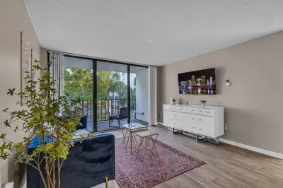 a living room with a white dresser and a large window at Stylish 2BR in North Miami with Free Parking in North Miami