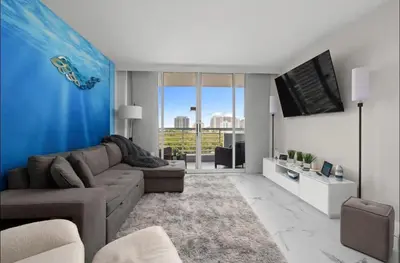 a living room with a couch and a flat screen tv at Family Tides At GalleryOne in Fort Lauderdale