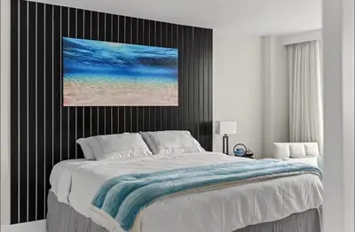 a bedroom with a large bed with a painting on the wall at Family Tides At GalleryOne in Fort Lauderdale