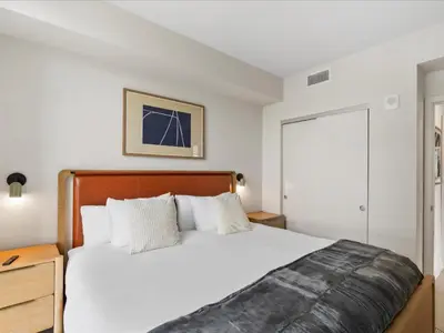 a bedroom with a large bed with a wooden headboard at Central Downtown Condo - Rooftop Pool Access in Miami
