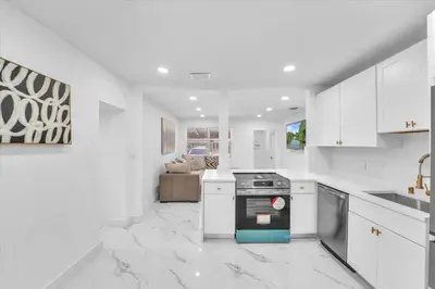 a white kitchen with a stove and a couch at Oasis With Pool and Putting Green in Hollywood
