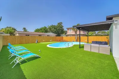 a yard with chairs and a swimming pool at Oasis With Pool and Putting Green in Hollywood