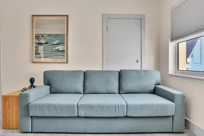a blue couch sitting in a living room at Santorini Blu Elegant 1BR Beach Retreat On the Beach in Hollywood