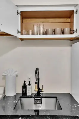 a kitchen counter with a sink and some dishes at Santorini Blu Elegant 1BR Beach Retreat On the Beach in Hollywood