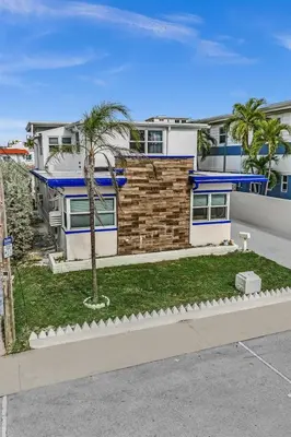 a house with palm trees in front of it at Santorini Blu Elegant 1BR Beach Retreat On the Beach in Hollywood