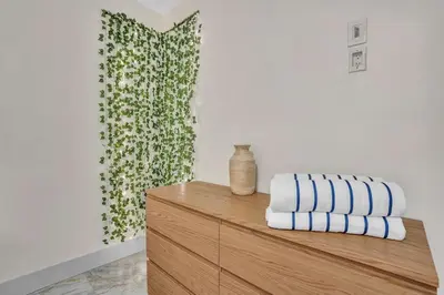 a room with a wooden dresser with towels on it at Santorini Blu Elegant 1BR Beach Retreat On the Beach in Hollywood
