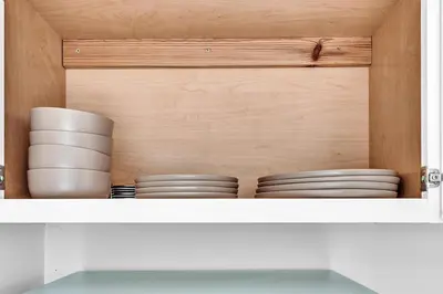 a cabinet with plates and bowls on a shelf at Santorini Blu Boutique Beach Studio Steps to Ocean in Hollywood
