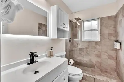 a white bathroom with a sink and a toilet at Santorini Blu Boutique Beach Studio Steps to Ocean in Hollywood