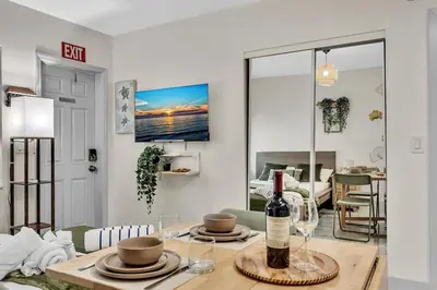 a bottle of wine on a table in a living room at Santorini Blu Stylish Coastal Studio on the Beach in Hollywood