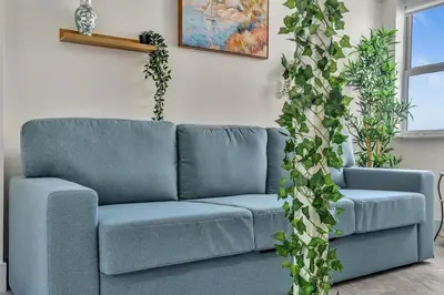 a blue couch in a living room with plants at Santorini Blu Spacious 2BR Beachfront Suite in Hollywood