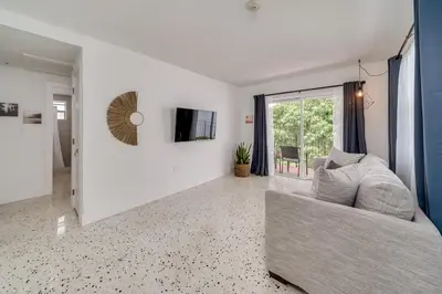 a living room with a couch and a tv at Wynwood Charm, at the Heart of the Art! in Miami